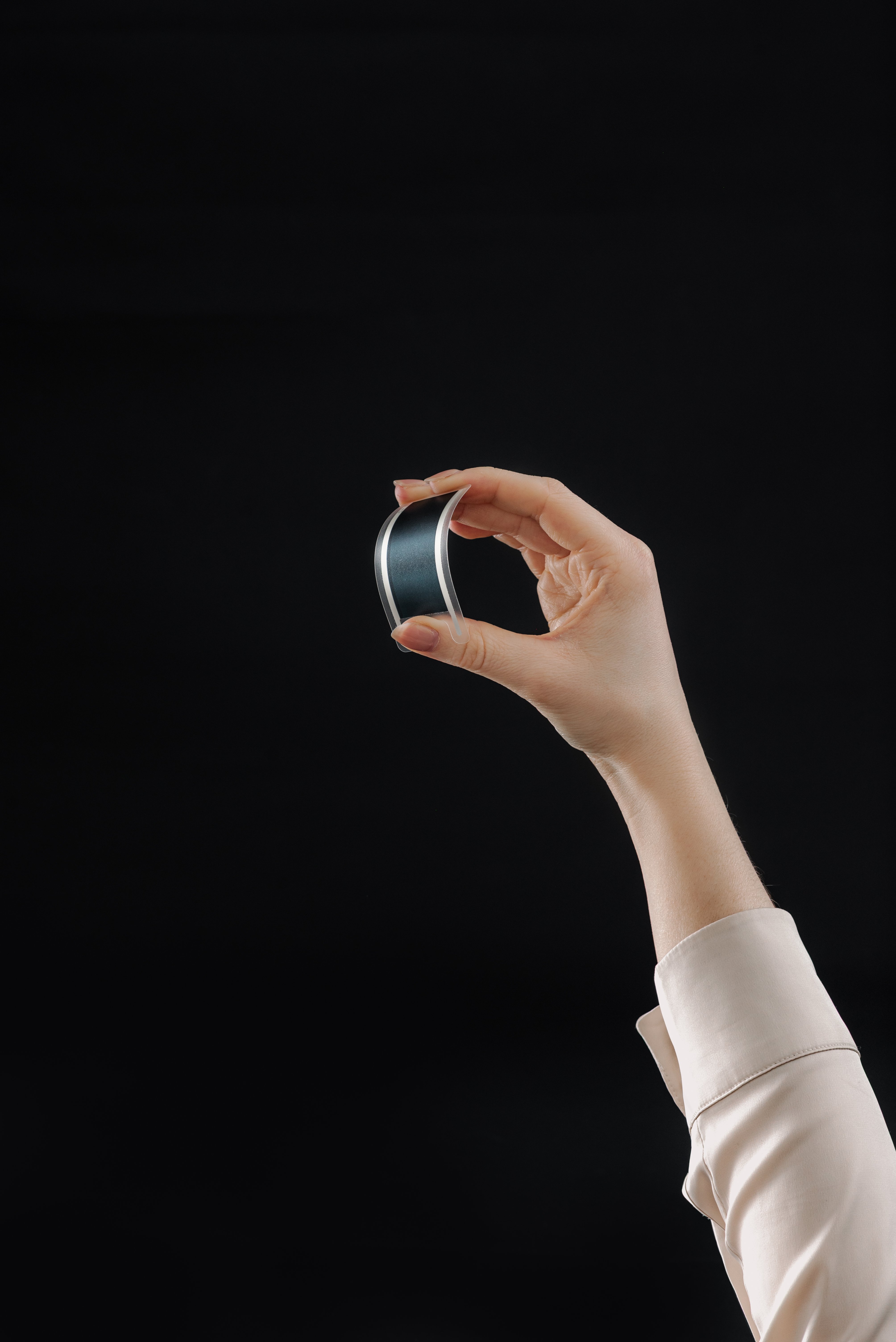 Hand holding an Epishine OneCell, an indoor photovoltaic cell